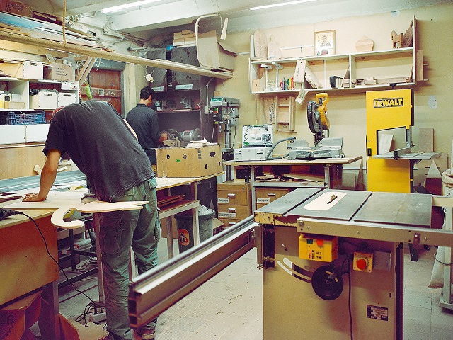 Мужчины работают в мастерской на даче